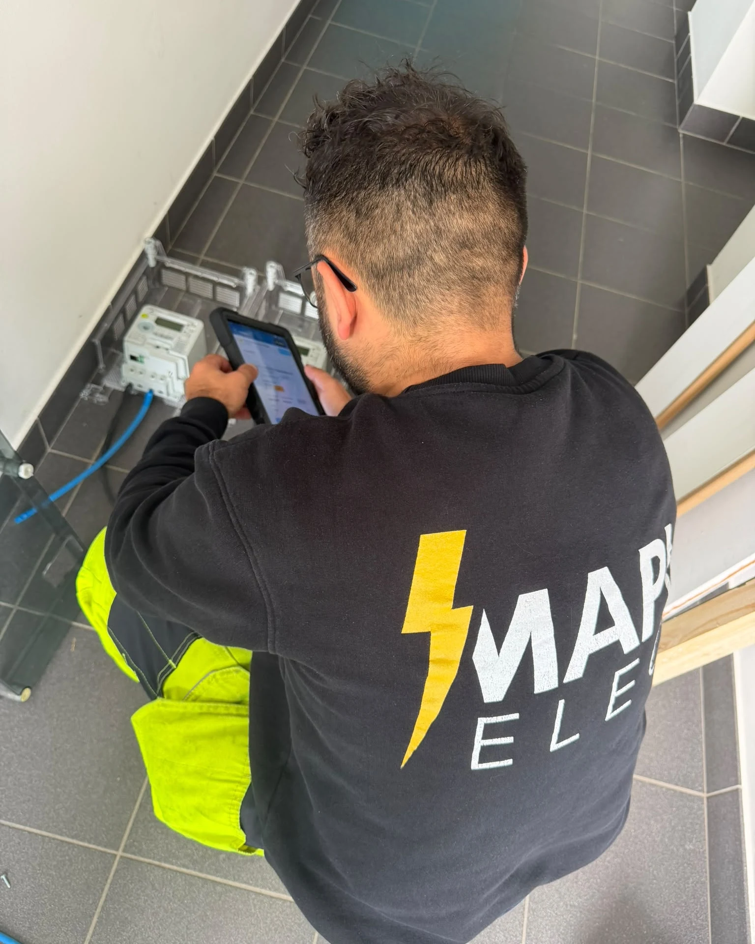 Technicien MAPI Elec saisissant une intervention sur tablette devant un compteur